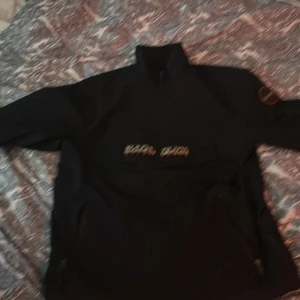 Svart jacka från Napapijri - Säljer en svart jacka från Napapijri med hög krage och dragkedja. Jackan har broderad logotyp på bröstet och ett runt märke på ärmen. Regular fit och tejpade sömmar. Perfekt för dig som vill ha en stilren och funktionell jacka.