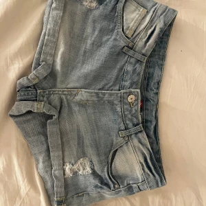 Ljusblå jeansshorts från H&M Divided - Säljer ett par ljusblå jeansshorts från H&M Divided med slitna detaljer och klassiska fem fickor. Skriv till mig om du har frågor eller vill ha fler bilder!💞