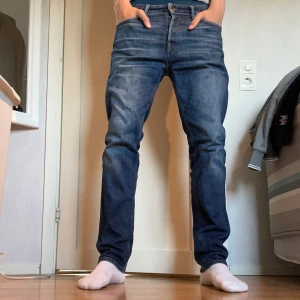 Blå jeansbyxor från  Jack and Jones  - Säljer ett par klassiska blå jeans från Jack and Jones  med normal passform och raka ben. Storlek 30 32