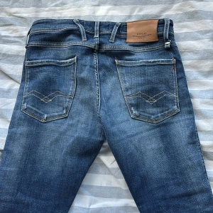 Blå Replay Anbass jeans - Säljer ett par klassiska blå Replay Anbass jeans med snygg tvätt och raka ben. Slim fit, storlek 30/32. Väldigt fint skick, endast några trasiga sömmar. Skriv om du har frågor o funderingar!