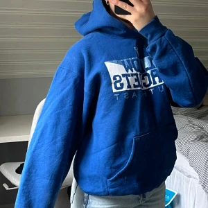 Blå hoodie med tryck  - Blå hoodie med tryck på bröstet. Den har huva och en stor magficka. Köptes i Barcelona på en thrift store💙