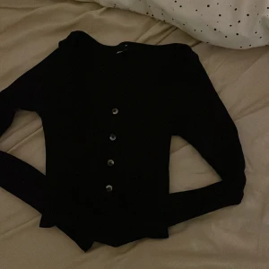 Snygg tajt top - Tajt svart top man kan ej öppna den knapparna är bara som dekoration