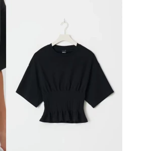 Svart topp med volang - Säljer denna fina toppen med markerad midja💕så fin och aldrig använd