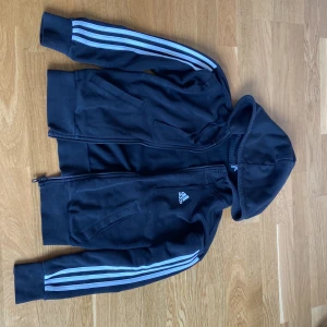 Adidas Tjocktröja Träning - En fet svart adidas tjocktröja med dragkedja 🔥 Är i väldigt bra skick och är inte förstörd/ skadad någonstans vad jag har sett! Den funkar perfekt som en basic tröja för sommareftermiddagen eller i träningsoutfiten 😍Säljs pga ingen användning‼️