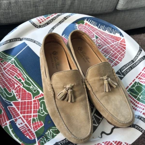 Loro Piana Roadster Walk (44) - Storlek 44 men skulle säga att de sitter som 43. Använda endast 1 gång! Snygga beige loafers i mocka från Loro Piana med dekorativa tofsar framtill. Skorna har en klassisk design med rund tå och platt sula, perfekta för en stilren look! 