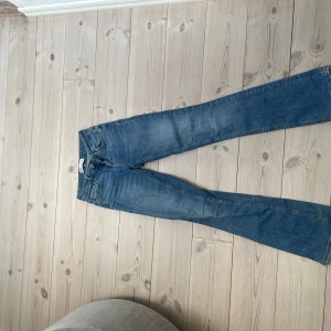 Blå bootcut jeans - Säljer ett par klassiska blå bootcut jeans med normal passform. Jeansen har fem fickor, dragkedja och knapp framtill. Perfekta för dig som gillar en tidlös stil med lite utsvängda ben, från zara.