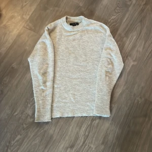 Ljusgrå stickad tröja från Amisu - Mysig ljusgrå stickad tröja från Amisu. Klassisk modell med rund halsringning och långa ärmar. Perfekt för lager-på-lager och enkel att matcha med olika outfits.