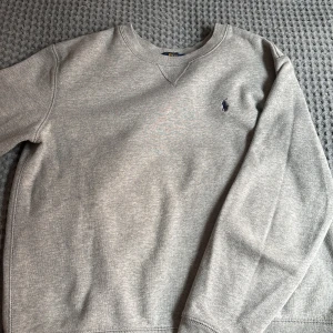 Grå sweatshirt från Polo Ralph Lauren - Säljer en grå skön tröja från Polo Ralph Lauren. Perfekt till lite små kyliga sommar kvällar! ☀️Tröjan är i barn storlek 14/16 men funkar även till xxs/xs. Jag är 168 och den är nästan för liten. Skicket är 10/10, köpt på KidsBrandStore för några år sedan men har aldrig passat mig. Därför aldrig använd ✅Skriv till mig vid minsta funderingen 👊🏼/Gustav