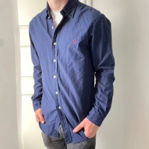 Blå Ralph Lauren skjorta - Skick, 10/10. Som ny, modellen är 180,75 kg och bär L, Slim fit. Passar honom bra men rekommenderar inte för mindre. Kom med frågor. Perfekt för skol avslutning 