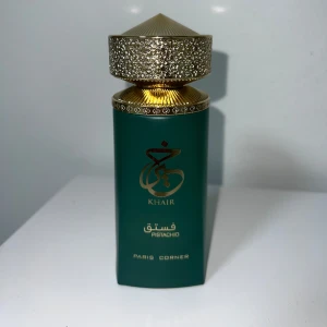 Ny oanvänd Khair Pistachio parfym Paris Corner EdP 100ml - Lyxig parfymflaska i mörkgrönt glas med gulddetaljer och orientaliskt mönstrad kork. Flaskan har elegant guldtext och heter Khair Pistachio. Perfekt för dig som gillar unika och exklusiva dofter. Ny, helt oanvänd, perfekta pistachio, Gormand doft, väldigt populär.