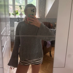 Grå stickad tröja med vida ärmar - Mysig grå stickad tröja med breda, långa ärmar och avslappnad passform. 