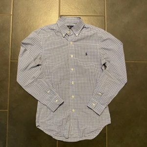 Blårutig skjorta från Ralph Lauren - Säljer en riktigt fett Ralph Lauren skjorta, perfekt till sommaren!  |  Storlek: S  |  Skick: 9/10 (som ny)  |  Passform: Slim fit  |   Om du har några frågor så är det bara att höra av sig! Kan gå ner i pris vid snabb affär!