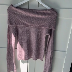Ljuslila offshoulder tröja Bik Bok XS - Supermjuk ljuslila stickad tröja från Bik Bok i mohairblandning. Offshoulder-modell med bred krage och långa ärmar. Perfekt för dig som vill ha en mysig men ändå snygg look. Sitter snyggt och är lätt att styla med jeans eller kjol.