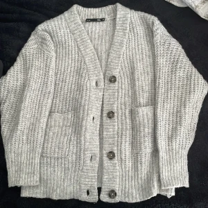 Stickad kofta - Grå jättemysig stickad kofta från Lager 157 i strl XS. Töjbar så passar även M-L. Säljes då den inte kommer till användning längre