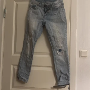 Ljusblå slitna jeans med hål - Säljer ett par ljusblå jeans med slitningar och hål på benen från New Yorker. 