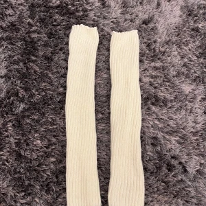 Långa ribbade benvita benvärmare - De är stickade och har en mjuk, vågig kant upptill som ger en söt touch. Perfekta att dra upp över knäna för en mysig och stilren look. Helt nya, oanvänd. 🤍