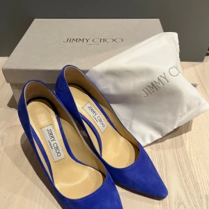 Blå mocka pumps från Jimmy Choo - Kornblå/koboltblå pumps från Jimmy Choo, sparsamt använda. Inköpta på NK i Stockholm. Storlek 37. Finns i Tullinge Trädgårdsstad Kommer från djur- och rökfritt hem. Kmmer med originalkartong och dustbag.