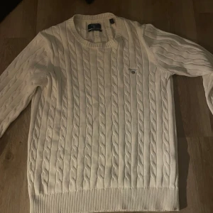 Vit kabelstickad tröja från Gant - Vit kabelstickad tröja från Gant i bomull. Klassisk rund halsringning storlek m passar mer s.