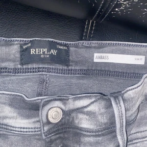 Replay Anbass grå slim jeans - Snygga grå jeans från Replay, modell Anbass med slim fit. Klassisk femficksdesign, raka ben och normal midja. Jeansen är i mjukt denimtyg och har en stilren, lite tvättad look som passar till det mesta.
