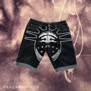 YLD Jeans Local Dealer svarta shorts - Unika svarta jeansshorts från YLD Jeans Local Dealer med stora vita tryck och broderier fram och bak. Shorts med loose fit, coola grafiska motiv och detaljerade sömmar. Perfekta för dig som vill sticka ut med streetwear-vibe och edgy stil.