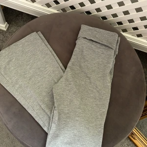 Gråa yoga pants från Gina Tricot - Superbekväma grå yogapants från Gina Tricot med vik midja och utsvängda ben. Tillverkade i mjukt bomullsmaterial som är perfekt för chill dagar eller när du vill vara extra comfy. Snygg och enkel design som funkar till allt.