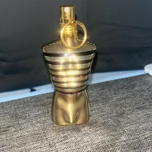 Jean Paul Gaultier le male elixir - Säljer en ikonisk herrparfym från Jean Paul Gaultier, Le Male elixir. Flaskan är formad som en manlig torso i guld med svarta och guldiga ränder och har en metallisk finish. Innehållet är bärnstensfärgat och flaskan har en snygg ringdetalj vid sprayhuvudet. Flaskan är 75ml men de finns kvar ungefär 60ml och doftar väldigt gott.