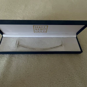 Silverarmband Hallbergs Guld 925 - Stilrent armband i äkta 925 silver från Hallbergs Guld. Kedjan är tunn och klassisk med platt länkmönster och smidig karbinhake. Perfekt för dig som gillar minimalistiska smycken med en tidlös vibe.