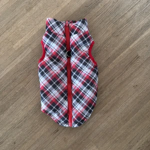 Jacka till hund  - Rutig jacka till hundar. Denna är i storlek S och passar till små hundar såsom taxar ich dvärgpudlar. Den är perfekt för hundar som fryser eller när det regnar ute. 