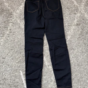 Svarta jeansbyxor med kontrastsömmar - Snygga svarta jeansbyxor med kontrastsömmar. De har en klassisk femficksdesign och en smal passform.