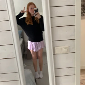 Ljuslila blommig volangkjol - Supersöt ljuslila kjol med blommigt mönster och volanger. Resår i midjan för extra komfort och en luftig känsla. Perfekt för dig som vill ha en feminin och somrig look. Första bilden visar färgen bäst. 