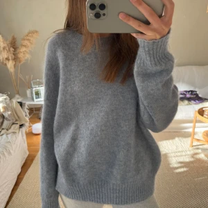 Ljusblå stickad tröja - Mysig ljusblå stickad tröja med långa ärmar och ribbade muddar. Perfekt för kyliga dagar och ger en avslappnad look. Passar bra till både jeans och leggings. Litet hål som ej syns därav priset 