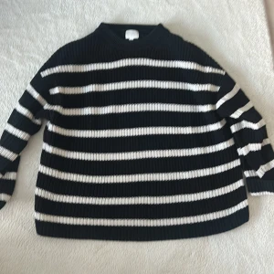 Svart och vit randig tröja - Säljer en svart och vit randig tröja med ribbad struktur. Tröjan har långa ärmar och en bekväm passform. Perfekt för en stilren look.