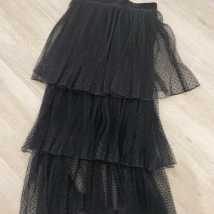 Svart långkjol med volanger - Säljer en svart långkjol i transparent mesh med små prickar och flera lager volanger. Passar perfekt nu i sommar💞