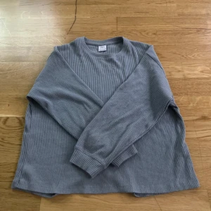 Grå- ljud blå ribbad tröja från Zara - Säljer en grå ribbad långärmad tröja från Zara i storlek M-S. Tröjan har en enkel och stilren design med rund halsringning och mjukt material. Perfekt för en avslappnad och snygg look.