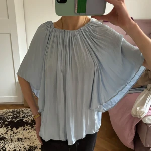 Ljusblå blus - Ljusblå, unik blus i glansigt material! Köpt på Åhléns, märket är Wera. Använd endast en gång🩵 200 kr + frakt