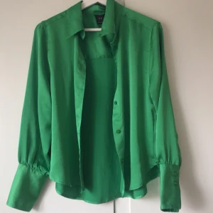 Grön blus  - Snygg grön blus med knappar framtill och långa ärmar i strl s. Perfekt för en färgglad look. Köpt på Lindex 
