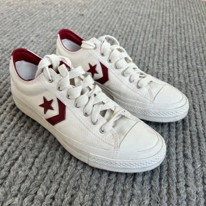 Vita sneakers Converse - Vita sneakers från Converse. Använda ett fåtal gånger. Vinröd stjärna på sidan av skon. Storlek 42 1/2.  
