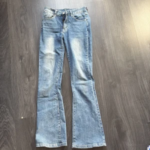 Blå bootcut jeans från Shein - Snygga blå bootcut jeans från Shein med dekorativa sömmar och nitar på bakfickorna. Midjan går precis under naveln men klassas inte som lågmidjade. Dom är använda men inte så att de syns 