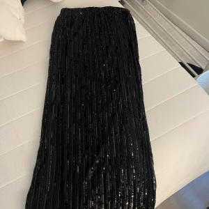 Svart långkjol med paljetter - Snygg svart långkjol med massor av glittrande paljetter 🪩 Rak passform. Använd 1 gång så den är i väldigt fint skick. Skriv meddelande vid frågor/fler bilder 🩷