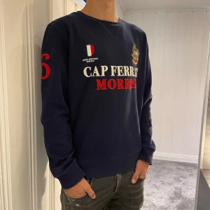 Mörkblå tröja från Morris - Säljer en snygg mörkblå tröja från Morris, vitt och rött på framsidan. ett broderat emblem på bröstet. Perfekt för en stilren look. Frakten är även helt gratis, det är bara att skriva om du har några funderingar svarar snabbt🤩✅