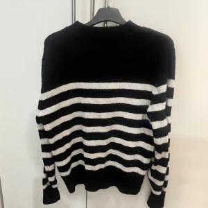 Svart och vit randig tröja - Säljer en stilren svart och vit randig tröja med långa ärmar. Perfekt för en avslappnad look. Tröjan har en klassisk design med horisontella ränder.