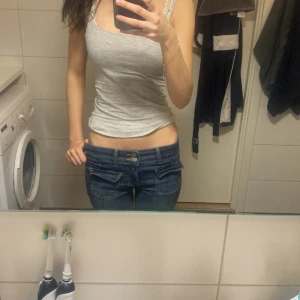 Nelly jeans - Säljer ett par klassiska blå jeans med bootcut-modell och låg midja. Jeansen har fem fickor, bälteshällor och dragkedja med knapp framtill. Perfekta för dig som gillar en avslappnad och tidlös stil.