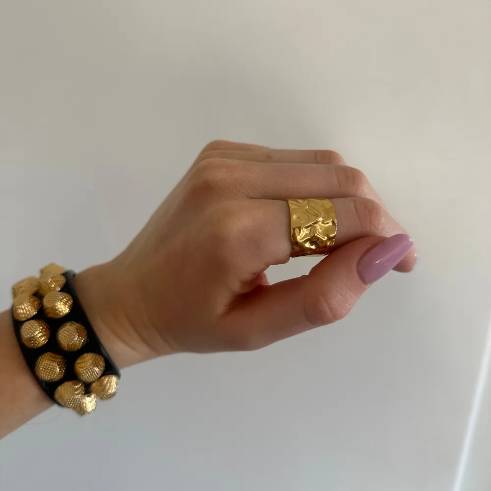 Snygg guldfärgad ring med en unik, skulpterad design. Stainless steel med guldplätering. Ringen är öppen och justerbar, vilket gör den lätt att anpassa till olika storlekar. Perfekt för att ge en elegant touch till din stil🤍. Asusteet.