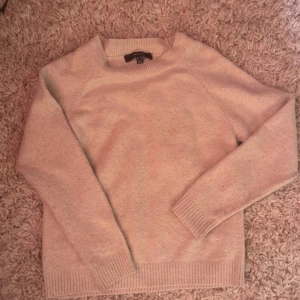 Beige stickad tröja - Mysig beige stickad tröja med långa ärmar och ribbade muddar. Perfekt för kyliga dagar.lite nopprig vi uddarna annars fin  