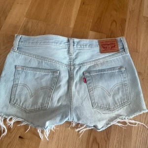 Ljusblå jeansshorts från Levi's - Ljusblå jeansshorts från Levi's med fransade benslut. W26