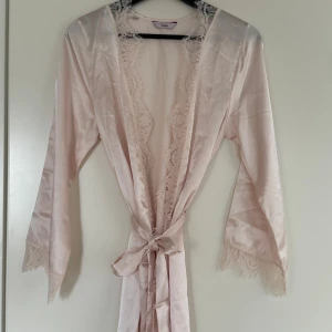 Ljusrosa spets-nattlinne sett - Säljer min nattlinne set med spetsdetaljer, i material satin. Den består av 3-delar; 1 kimono med knytband, 1 linne med smala axelband och spets, 1 matchande shorts med spetskant. Nypris: 599kr, säljer för endast 389kr. Priset kan diskuteras🌸