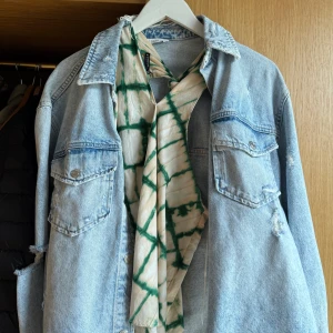 Grön och vit ärmlös top - Säljer en ärmlös top med knyt i nacken och grönt rutmönster på vit botten. Toppen har en luftig passform och är perfekt för varma dagar. Materialet känns lätt och bekvämt.