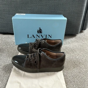 Svarta sneakers från Lanvin med lackad tå - Lanvins uk 8 vilket motsvarar 42/43. Köp för endast 1799. Allt ingår så som box samt dustbag. 