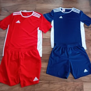 Tränings set från Adidas - Säljer två fotbollströjor från Adidas. En röd med vita detaljer och en blå med vita detaljer. Det röda setet är i storlek 164 och det blå är i 152