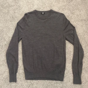 Grå tunn stickad tröja från Uniqlo - Säljer en enkel och stilren grå stickad tröja från Uniqlo. Tröjan har rund halsringning och långa ärmar.